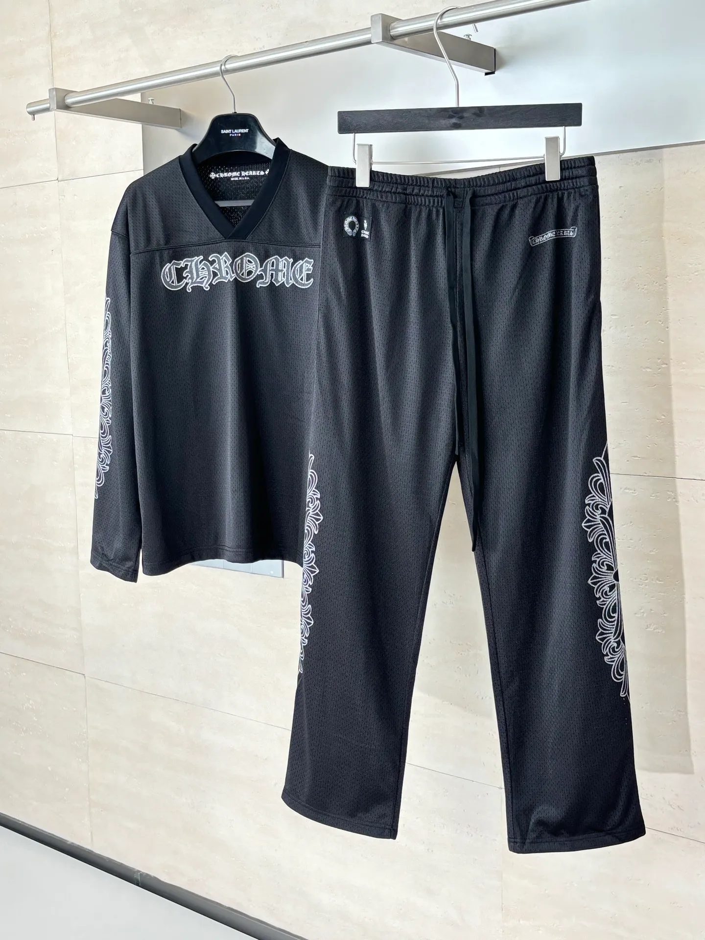 P340 Chrome Heart*/Chrome Heart Sanskrit mesh ice hockey suit straight trousers. The original version was purchased for 15,989 and developed. The fabric is made of custom weaving and dyeing technology. It is made of selected black mesh fabric, showing a unique sports style. The fabric has been specially treated to provide excellent breathability and comfort while maintaining a crisp and structured look. The double-layer design structure enhances the overall texture and makes the wearing experience more three-dimensional and full. The brand's iconic patterns are printed in many places, and high-precision printing technology is used to ensure that the patterns are clear and sharp. The silver printing has a glitter effect, showing charming luster changes under different lights. All printings undergo strict color difference control to ensure accurate color reproduction. The silver-plated pattern design on the sleeve arms is particularly eye-catching, showing the brand's consistent dark luxury style. In terms of details, the latest custom-woven labels are used, and the workmanship is exquisite. The overall shape is designed for both men and women, with both fashion and practicality. This T-shirt perfectly combines sports elements with high fashion craftsmanship, making it the brand's iconic street style item.  Size：S/M/L
